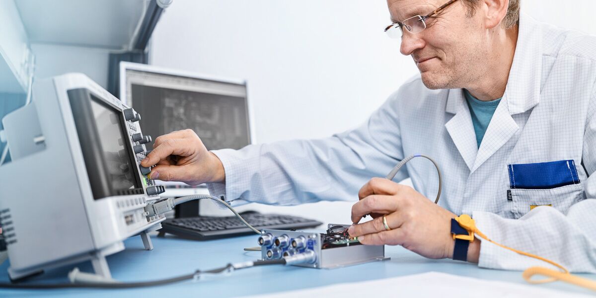 SMART TESTSOLUTIONS employee performs a measurement on an electronic assembly.